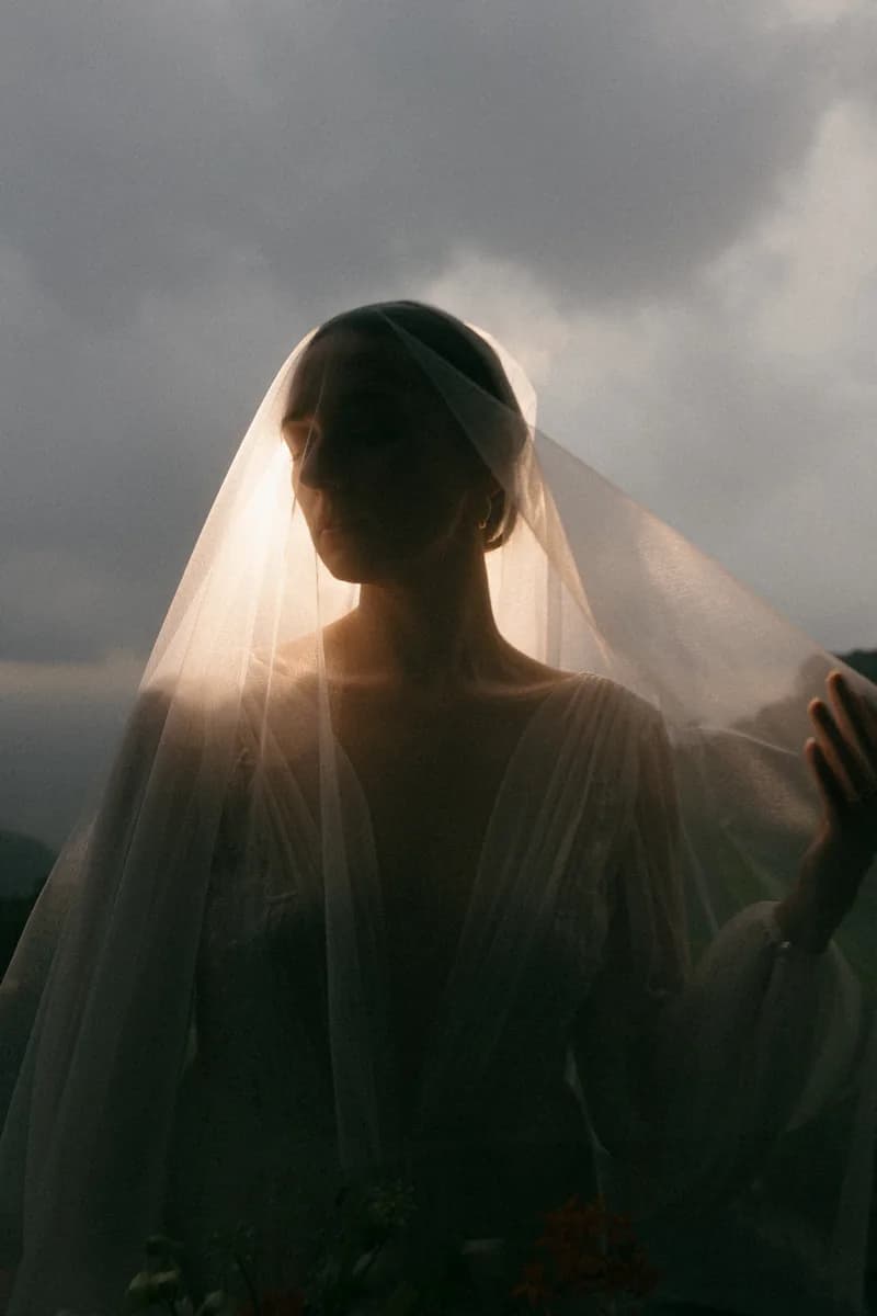 Bride under a backlit veil at dusk